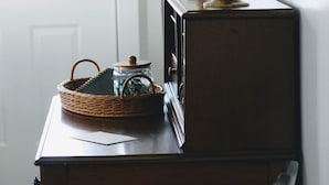 Ein Holztisch mit einer Lampe, einem Korb und einem Einmachglas.