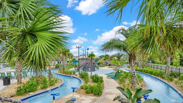 A pool area with palm trees, a slide, and a pathway. - Big house: private pool | Resort | Near Disney (Kissimmee)