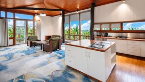 A modern kitchen with a wooden ceiling, large windows, and a view of greenery. - Rainbow Holiday Resort (Nadi)