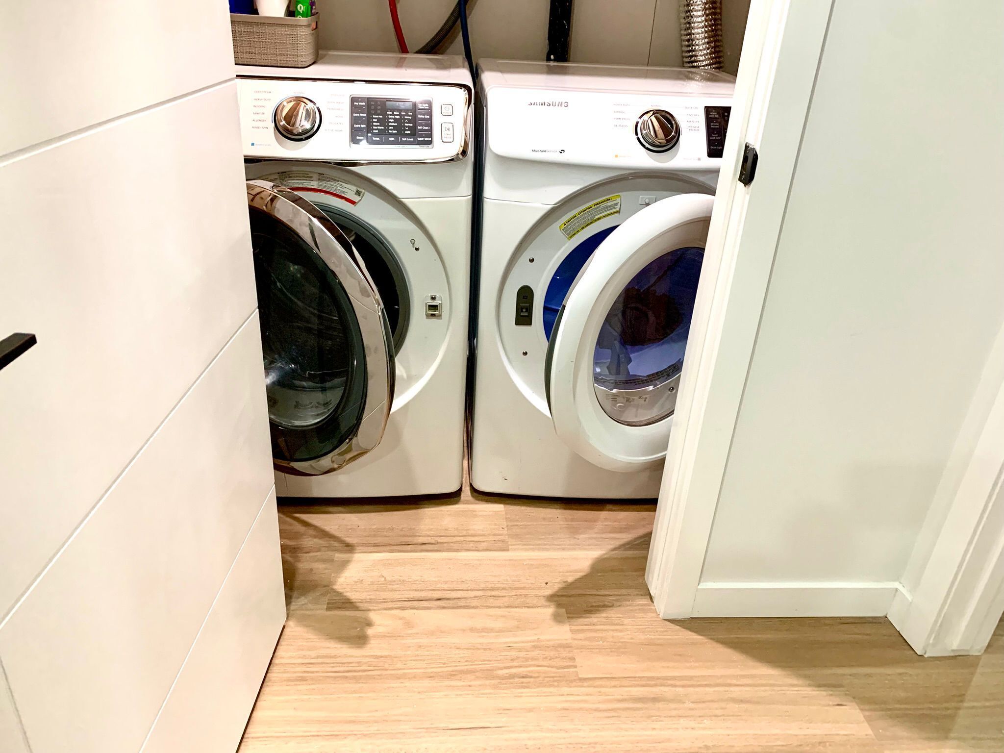 Une buanderie équipée de deux machines à laver à chargement frontal et d’un sèche-linge.