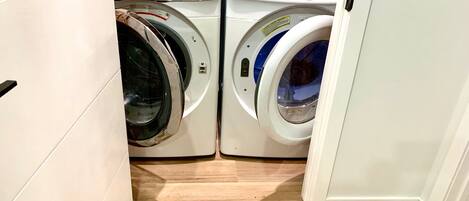 Une buanderie équipée de deux machines à laver à chargement frontal et d’un sèche-linge.