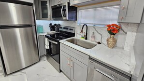 A modern kitchen with stainless steel appliances, a microwave, and a sink.