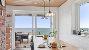 En matplats med utsikt över havet, ett träpanelat tak och en tegelvägg.