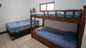 A room with two bunk beds, a window, and an air conditioning unit.