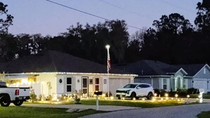 A residential area with houses, a driveway, and a flagpole.