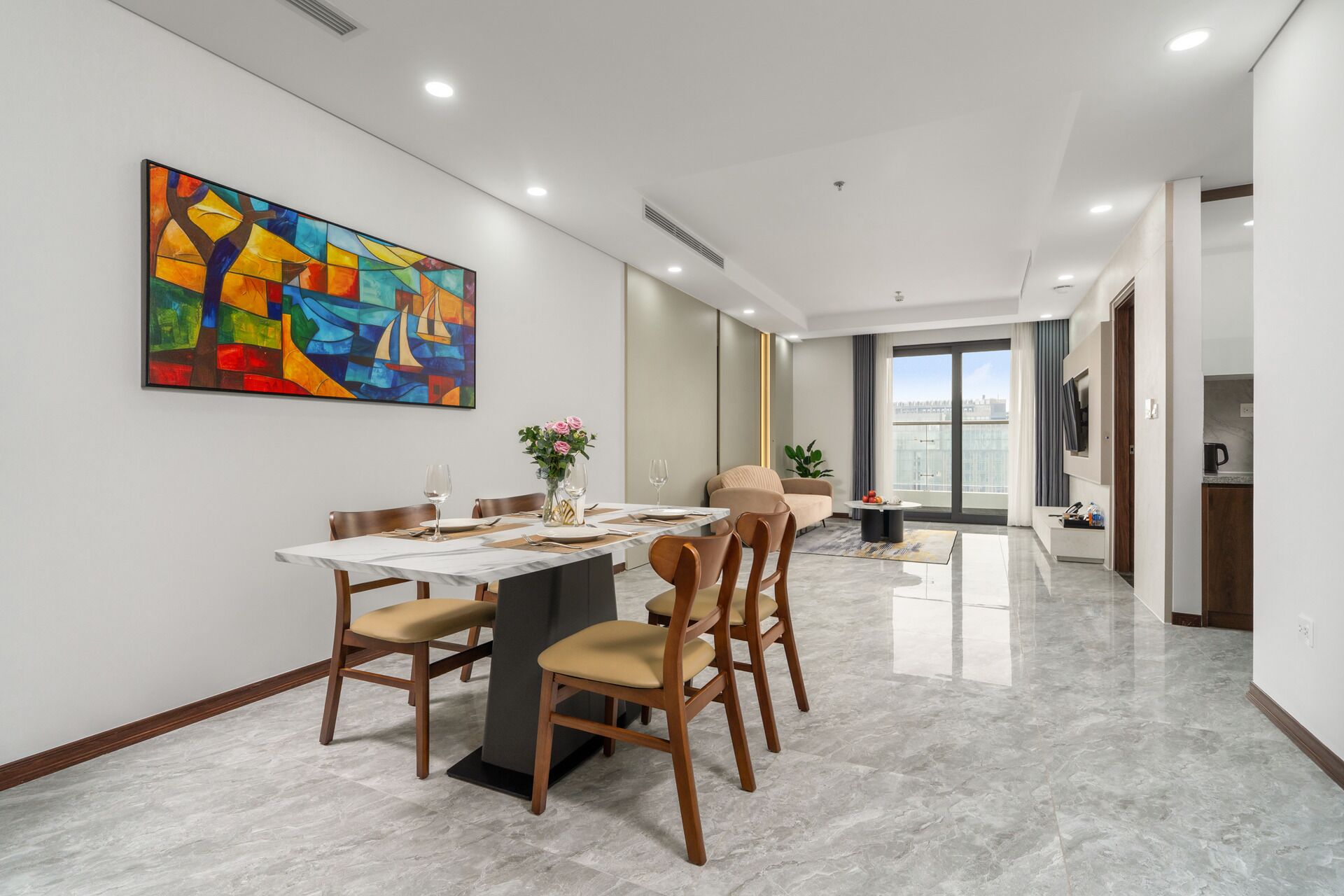 A modern dining area with a marble table, wooden chairs, and a colorful abstract painting on the wall.