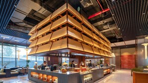 A modern kitchen with a central island, built-in appliances, and a high ceiling with exposed ductwork. - ARAVELLE SUITES (Hanoi)
