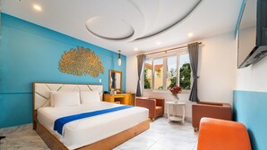 A modern hotel room with a large bed, a desk, a chair, and a view of the outside.