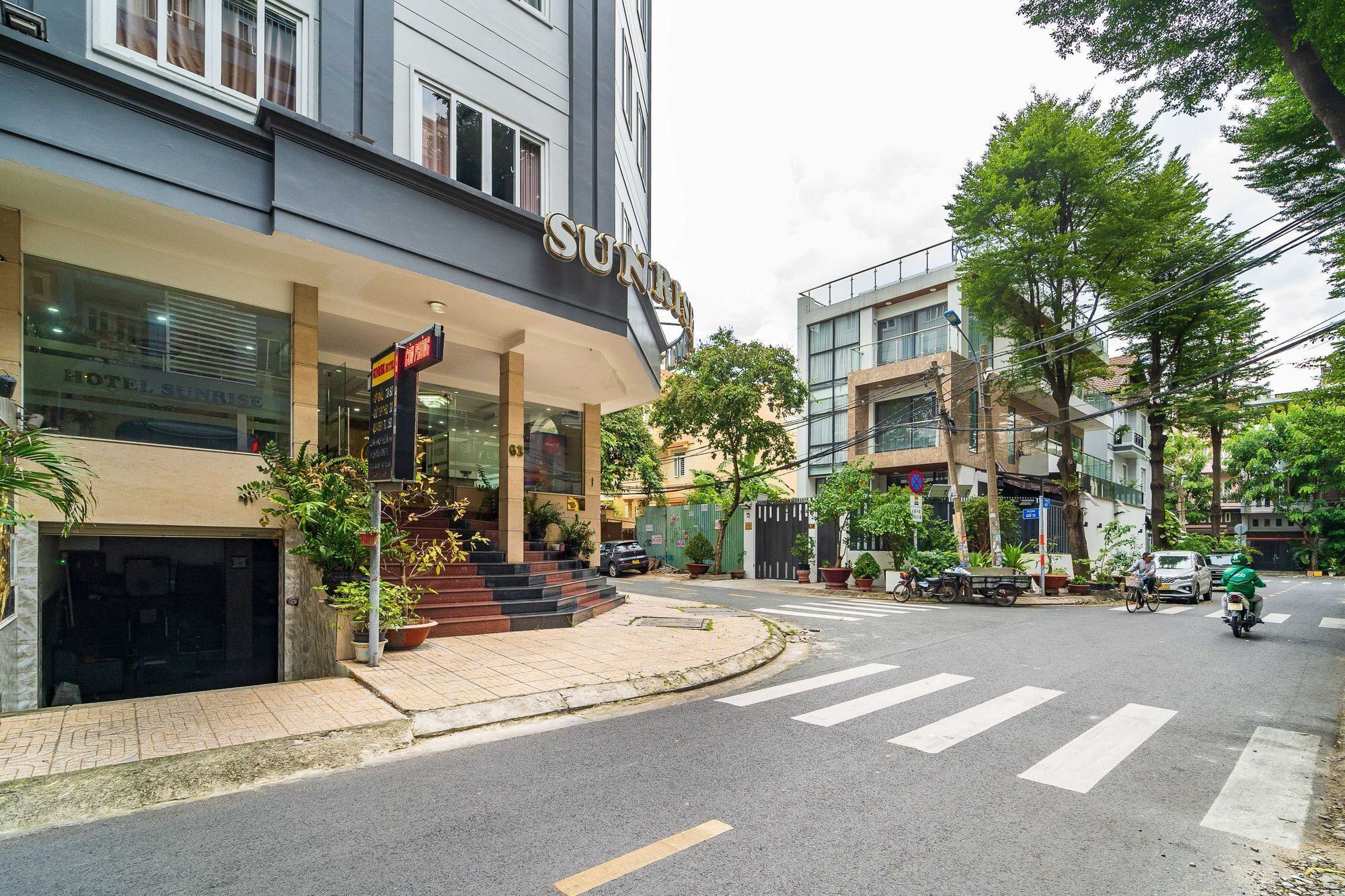 A hotel with a modern facade, a visible entrance, and a crosswalk in front.