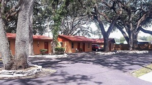 A row of motel buildings with red roofs, surrounded by trees. - Star Motel (Tampa)
