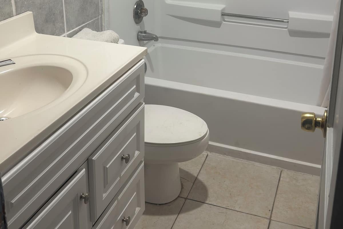 A bathroom with a white sink, a toilet, and a bathtub.
