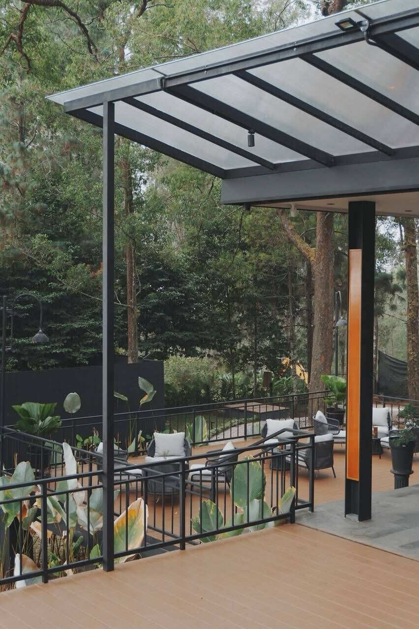 An outdoor patio area with a pergola, seating, and potted plants.