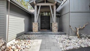 A house with a stone entrance, a garage door, and a stone pillar on the right.