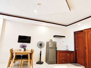 A compact kitchen with a refrigerator, a microwave, and a sink. - New Era Hotel & Apartments (Da Nang)