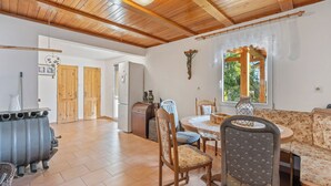 Una sala de estar acogedora con vigas de madera, un comedor y una cocina.