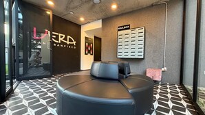 A massage room with a black leather sofa, a mailbox, and a tiled floor. - Views of the capital and volcano of San Salvador. (San Salvador)