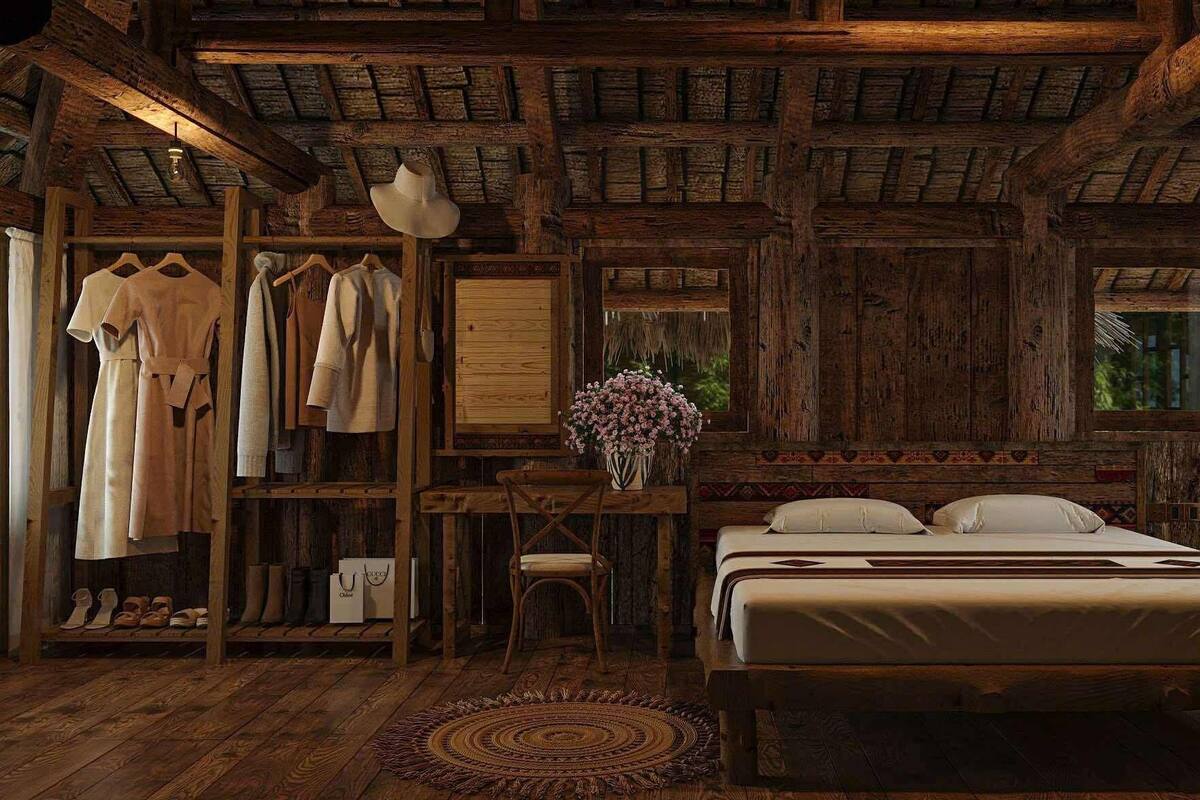 A rustic wooden room with a bed, a clothing rack, a desk, and a window.