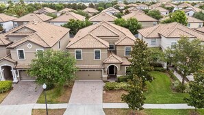 A residential area with multiple houses featuring pitched roofs and a well-maintained lawn. - Resort Stay w/ Pool & Amazing Amenities (Davenport)