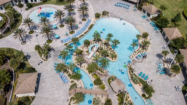 An aerial view of a resort with multiple swimming pools, palm trees, and lounge areas. - Resort Stay w/ Pool & Amazing Amenities (Davenport)