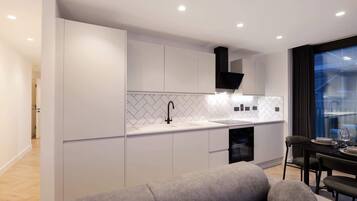 A modern kitchen with white cabinetry, a black faucet, and a herringbone tile backsplash.