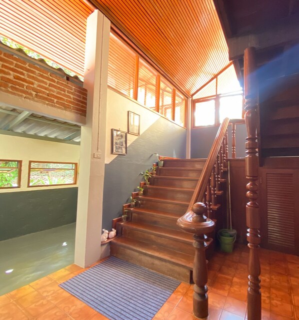 A staircase with wooden railings and a handrail, leading to an upper floor.