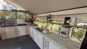 Una cucina compatta con mobili bianchi, un piano di lavoro nero e una macchina da caffè.