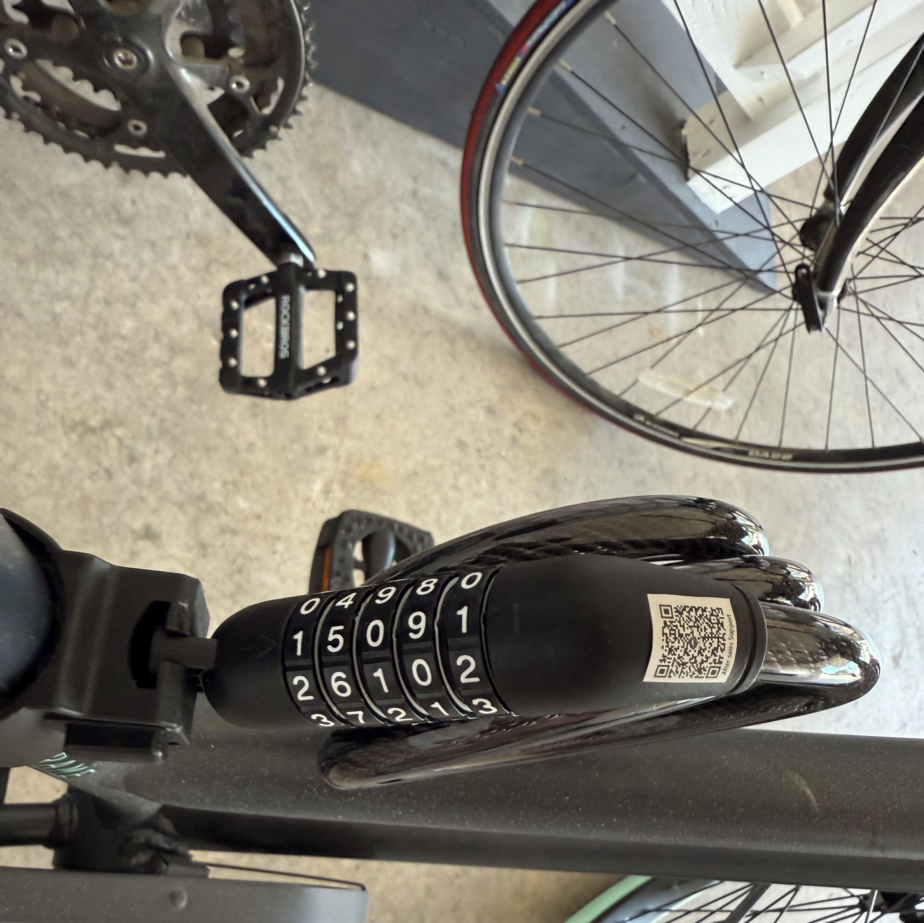 A bicycle with a numeric keypad and a QR code on the handlebar.