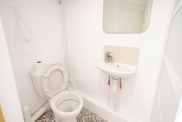 A bathroom with a toilet, sink, and shower.