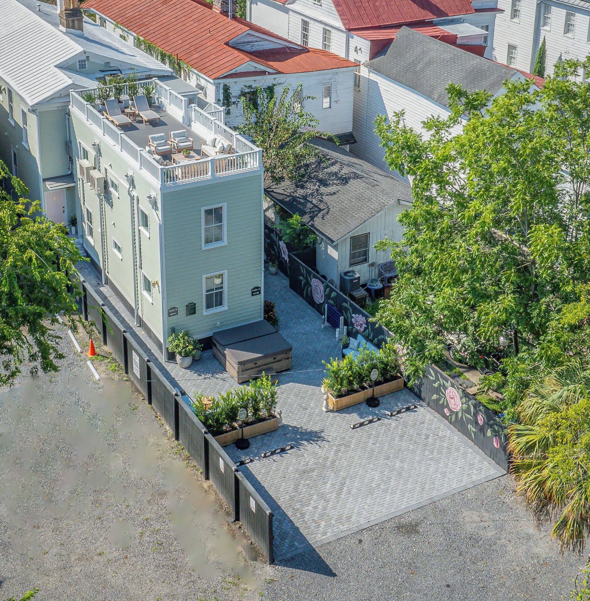 A multi-story building with a rooftop deck, outdoor seating, and a garden area.