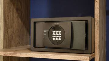 A black security keypad with instructions for use, placed on a wooden shelf against a blue wall.