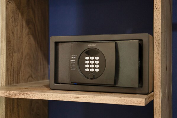 A black security keypad with instructions for use, placed on a wooden shelf against a blue wall.