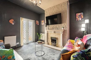 A living room with a fireplace, a television, and a couch. - Quiet Garden Home w/ Free Street Parking & Fast WiFi (Kingston upon Hull)