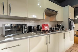 A modern kitchen with stainless steel appliances, a built-in oven, and a range hood. - Quiet Garden Home w/ Free Street Parking & Fast WiFi (Kingston upon Hull)
