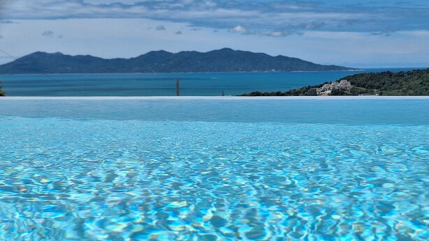 A clear view of an infinity pool with a mountain backdrop.