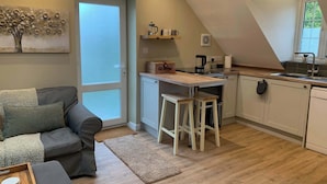A compact living space with a kitchenette, a sofa, and a dining area. - The Frog, Langport Luxury (Huish Episcopi)