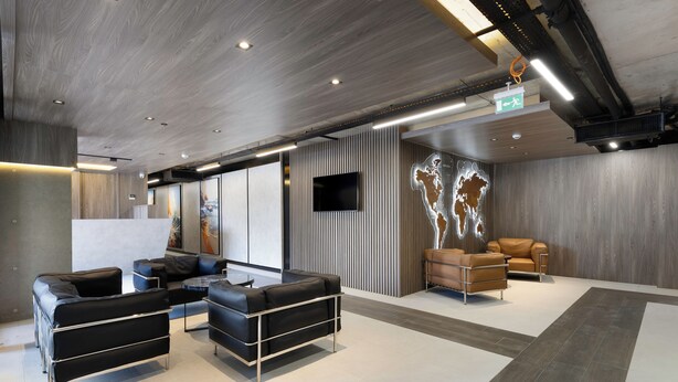 A modern lobby with leather seating, a flat-screen TV, and a world map mural. - Sunset Residence & Hotel Batumi (Batumi)