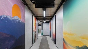 A hallway with a long, narrow corridor, flanked by large, colorful murals depicting landscapes. - Sunset Residence & Hotel Batumi (Batumi)