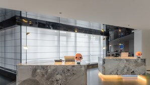 Un espace d’accueil moderne avec des comptoirs en marbre, un ordinateur portable et des objets décoratifs.