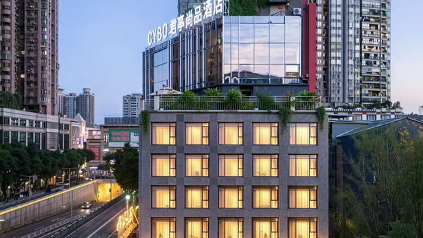 Un hôtel moderne, avec une enseigne indiquant « CYBO » et une grande façade en verre.