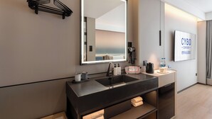 Une salle de bain moderne dotée d’un grand miroir, de deux vasques et d’un porte-serviettes.