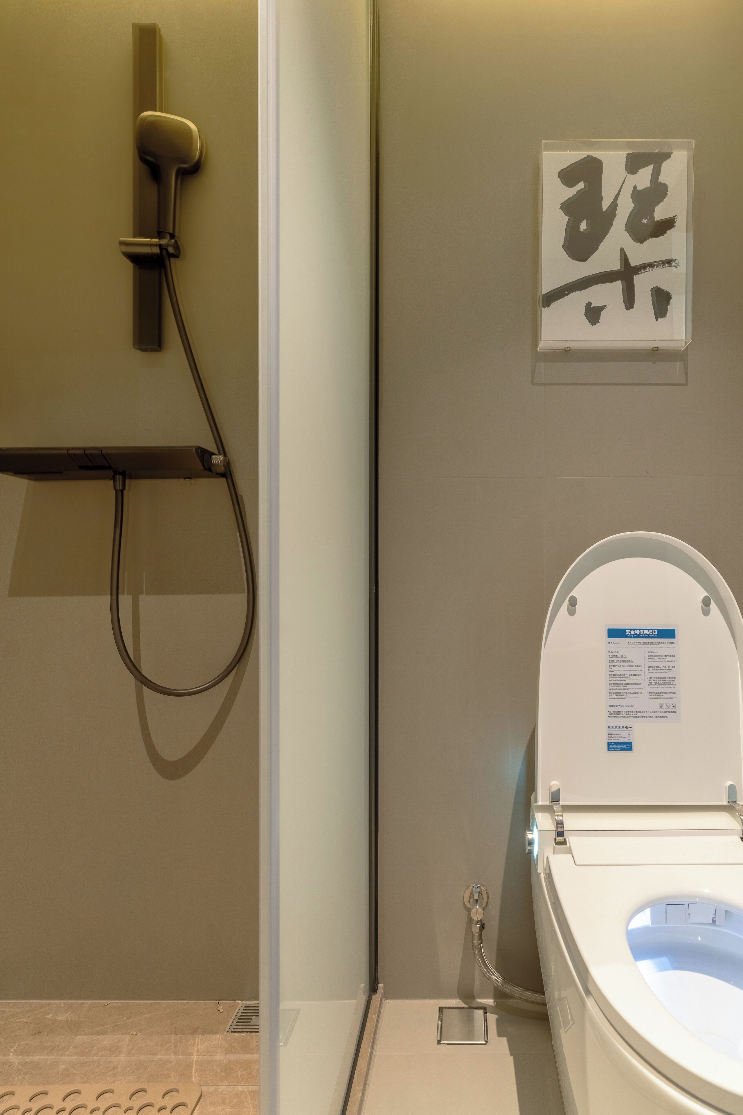 A bathroom with a toilet, a shower, and a wall-mounted sign.