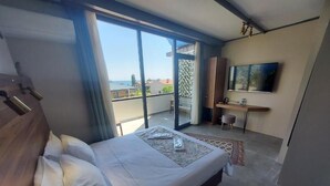 A bedroom with a bed, a TV, a desk, and a balcony with a view. - Queen Seagull Boutique Hotel (İstanbul)
