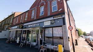 Un edificio con un letrero que dice 'Bentley's Hotel' y una 'Cafetería' al otro lado de la calle.
