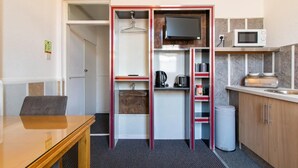 Une petite cuisine équipée d’un four à micro-ondes, d’une bouilloire et d’un petit réfrigérateur.