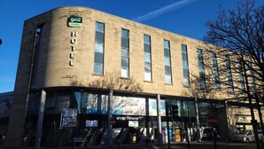 A hotel with a large sign reading "HOTEL" and a smaller sign for "902 hotels". - Standard Family of 3 Room (Lancaster)