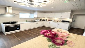 A modern kitchen with white cabinets, a black stove, and a wooden countertop. - Standard Double Studio (Pembroke Dock)