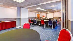 A conference room with a long table, multiple chairs, a projector screen, and a whiteboard. - Aston Court Derby City Centre Standard Single Room (Derby)