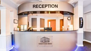 A reception desk at Aston Court Hotel with a clear sign, a clock, and a framed picture on the wall. - Aston Court Derby City Centre Standard Single Room (Derby)