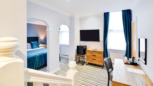 A hotel room with a bed, a desk, a TV, and a window with curtains. - Aston Court Derby City Centre Standard Single Room (Derby)