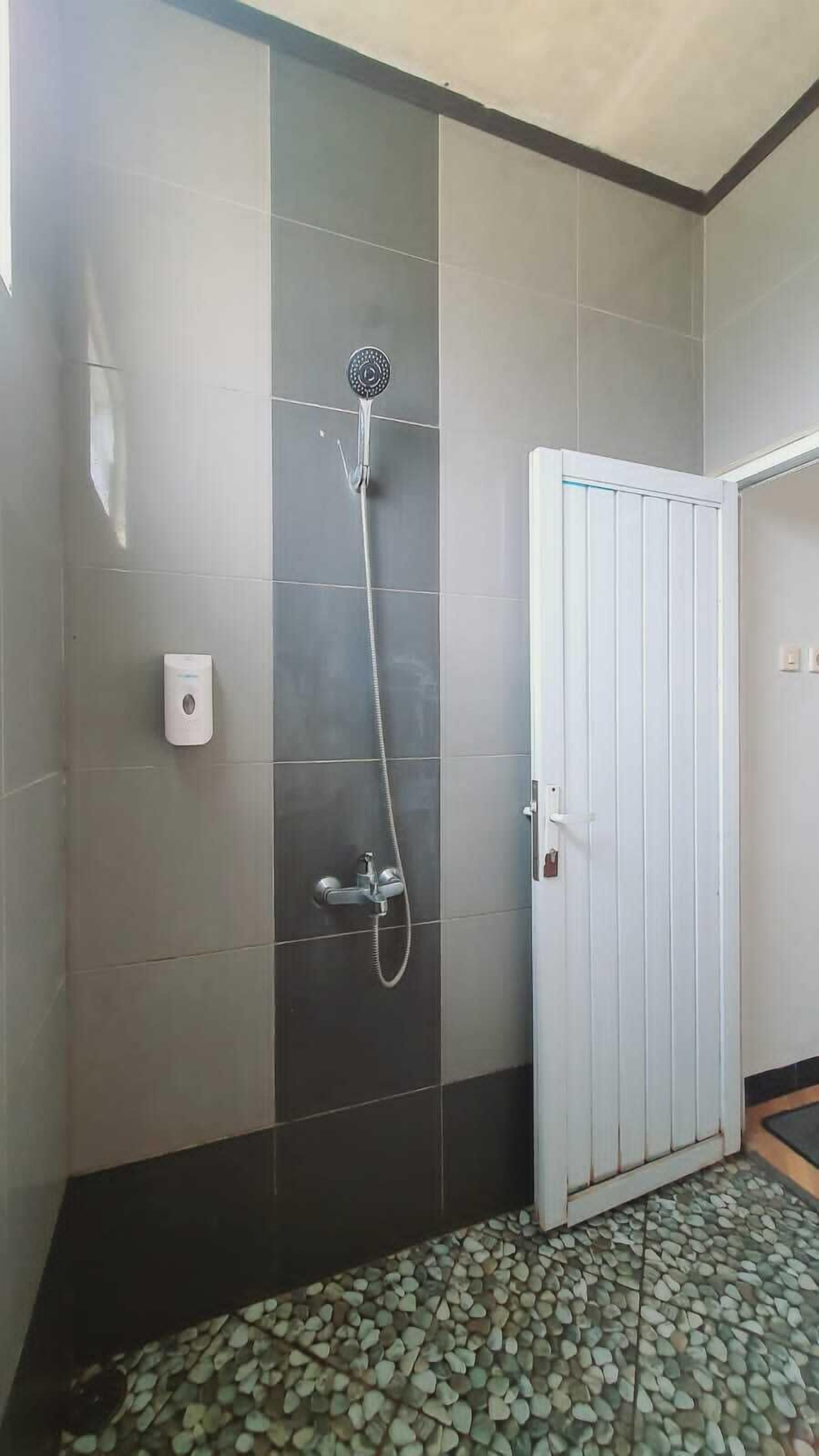 A bathroom with a shower, a toilet, and a sink.